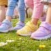 Vidám tavaszi gyerekcipő a réten játszó gyerekekkel és színes mintákkal